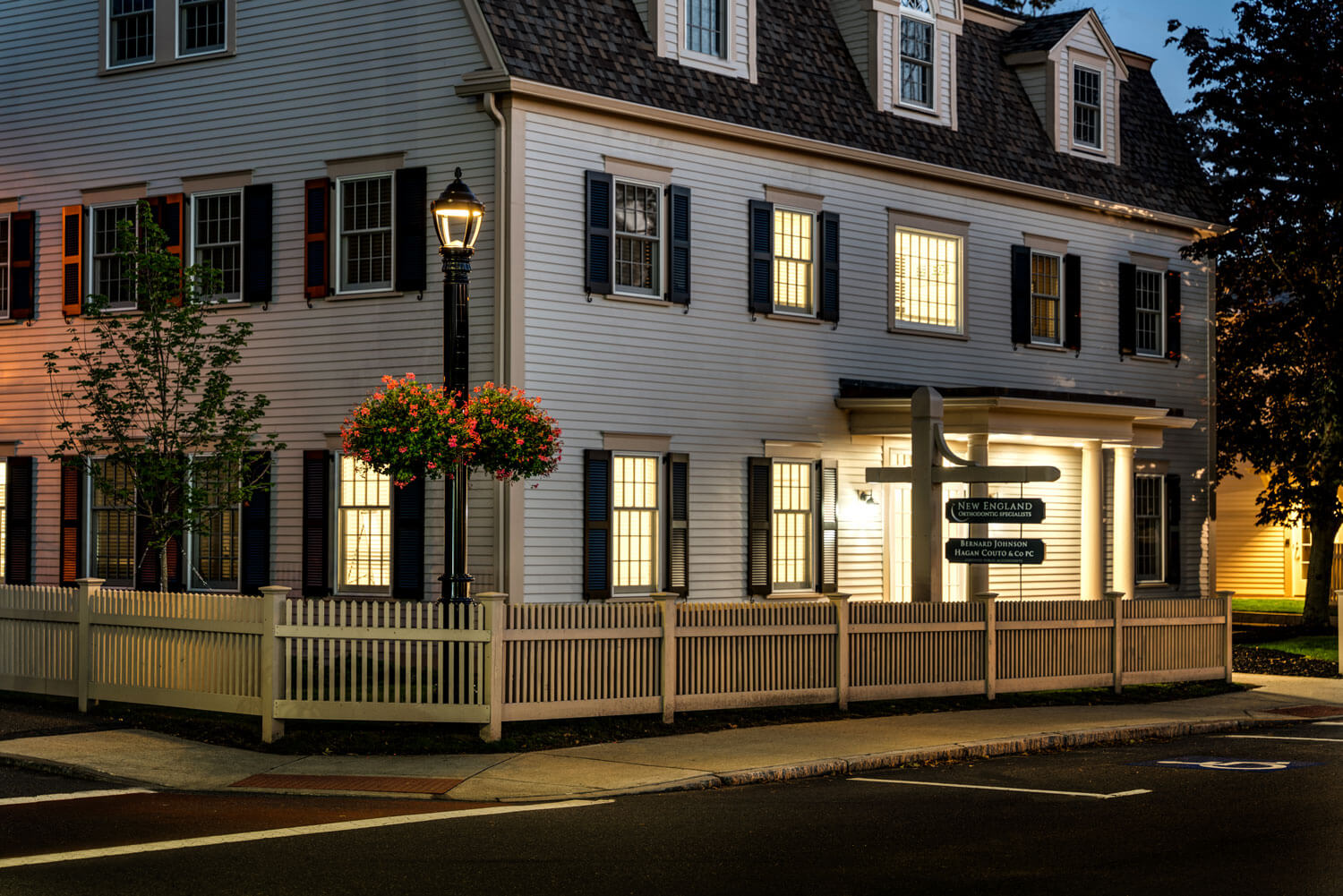 Soluxio-solar-street-light-Topsfield Soluxio solar street lights with classic city fixtures and flower plant hangers illuminating a street in Topsfield at night