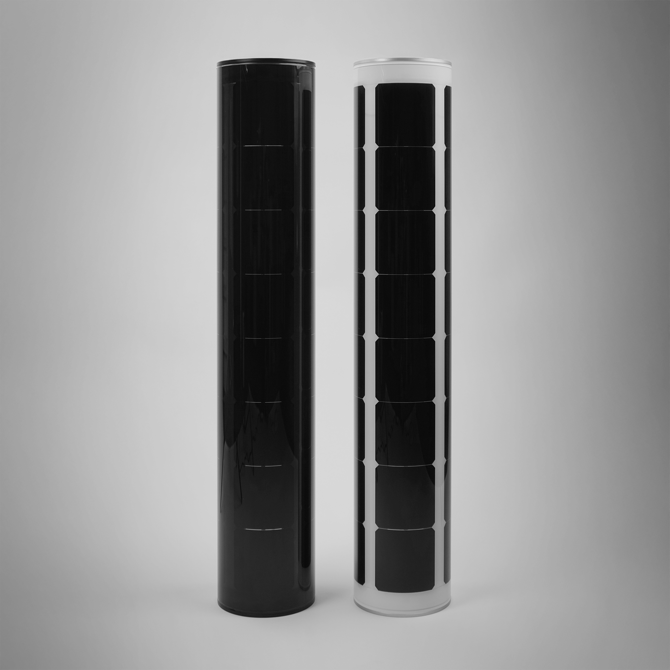 Black and white Soluxio cylindrical solar modules showcased side by side in a studio setting