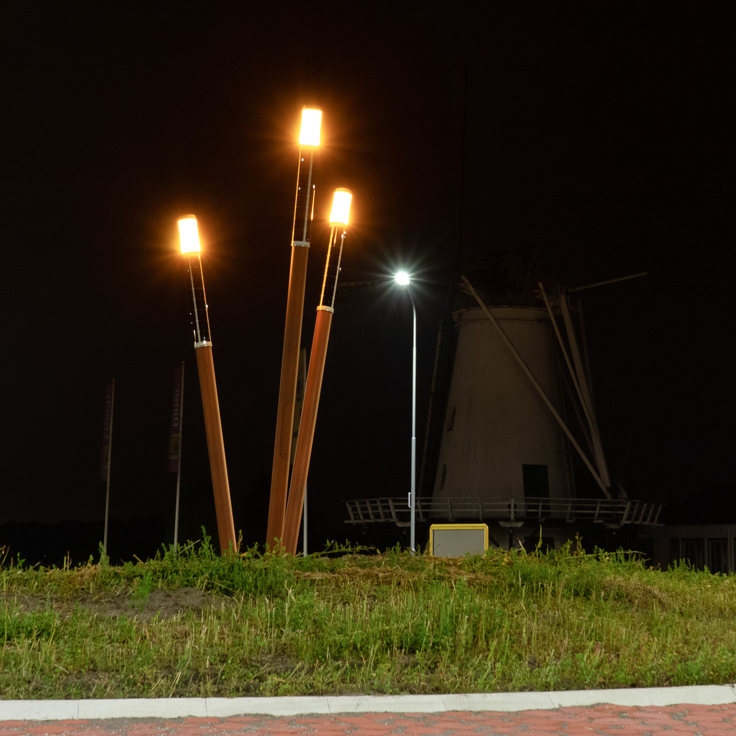 Amber-colored Soluxio Lightsticks solar lights illuminating a pathway with modern design